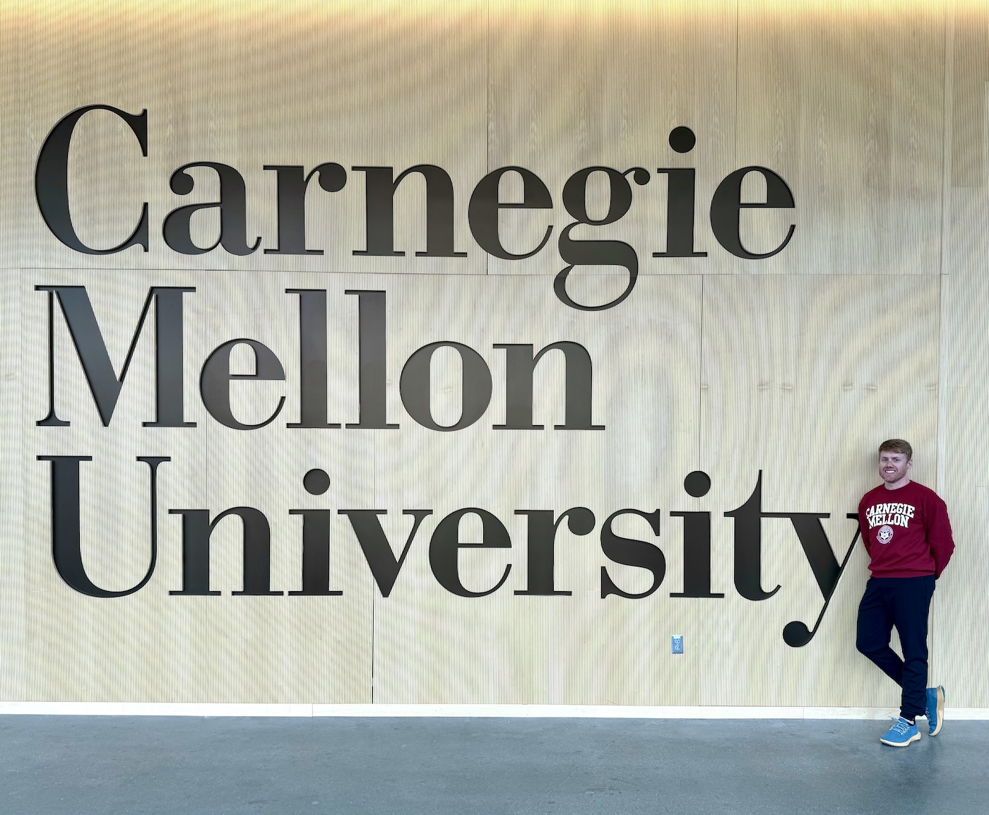 Me standing by a large Carnegie Mellon University sign.